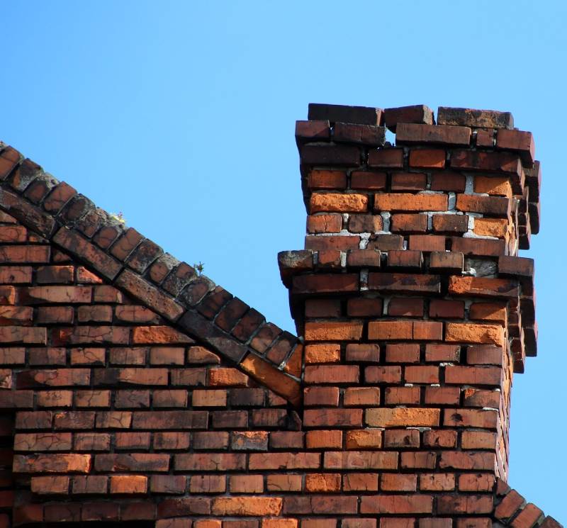 Damaged chimney on an Itasca home showing cracks and missing mortar